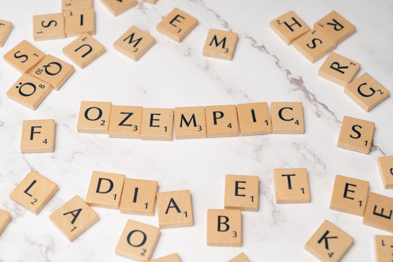 services-02 Scrabble tiles spelling Ozempic and diabetes on a marble surface.