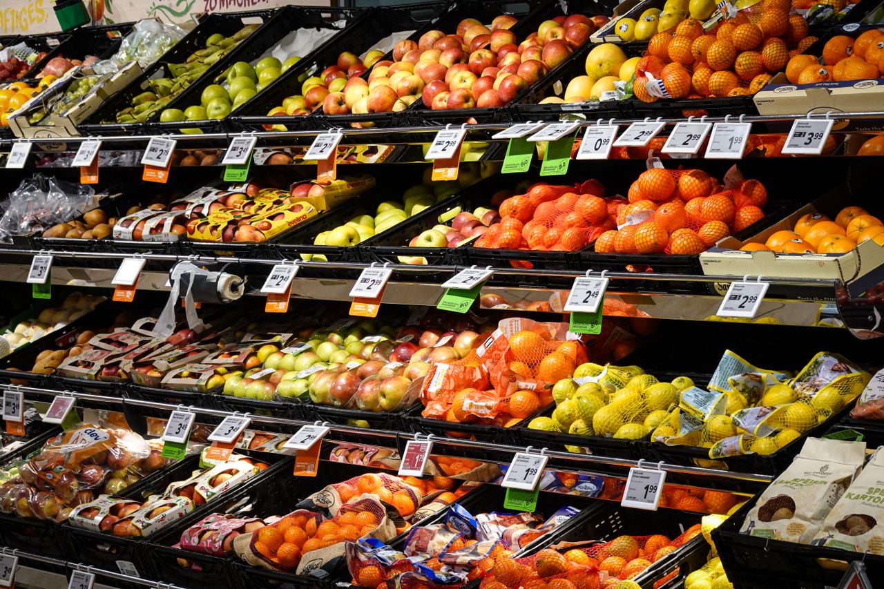 about-01 Colorful assortment of fresh fruits neatly arranged on supermarket shelves, ideal for healthy eating themes.